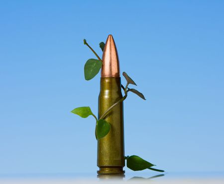 Young plant curves around cartridge over blue background の写真素材