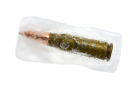 Bullet frozen in block of ice, isolated on whiteの写真素材