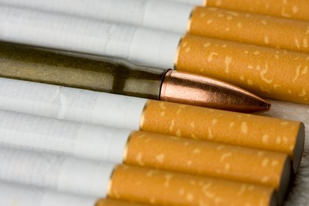 Cartridge in row of cigarettes - danger addiction conceptの写真素材