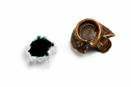 Seamy side of target with bullet hole and used bullet isolated on white の写真素材