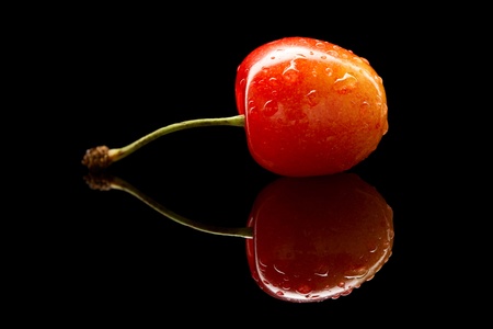 Sweet cherry over black reflective planeの写真素材