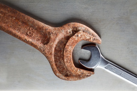 Wrenches over metal plate - age and size contrast, opposition conceptの写真素材