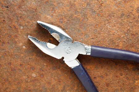 Macro of stainless pliers on rusted iron plateの写真素材