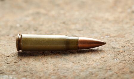 Close-up of kalashnikov bullet on rusted iron plateの写真素材