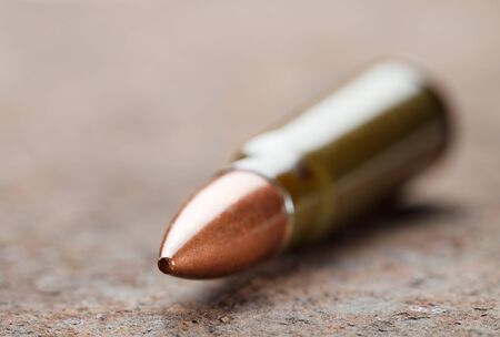 Macro of kalashnikov bullet over corroded iron plateの写真素材
