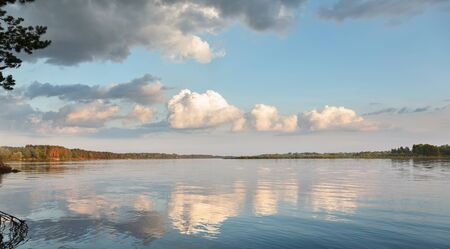 Panorama of idyllic morning landscape - clouds and blue sky reflected in calm waterの写真素材