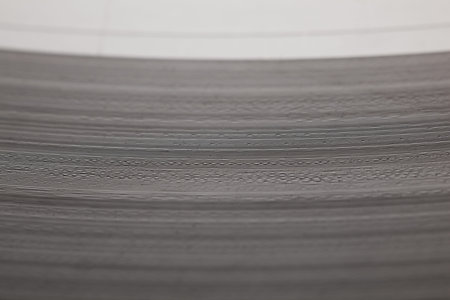 Selective focus macro of soundtrack grooves on old-fashioned vinyl music plate surfaceの写真素材