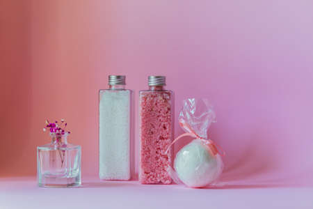 White beads, pink shimmer, white bath bomb stand on a purple background.の写真素材