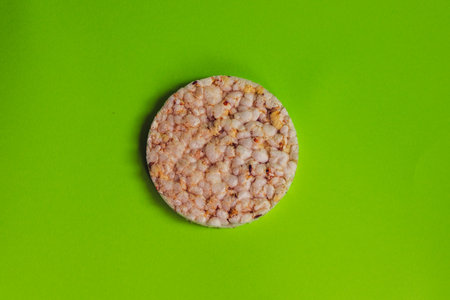 Corn and rice loaf with chia close-up on a bright green background.