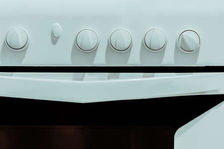 White kitchen gas stove with knobs for adjusting close-up.の写真素材