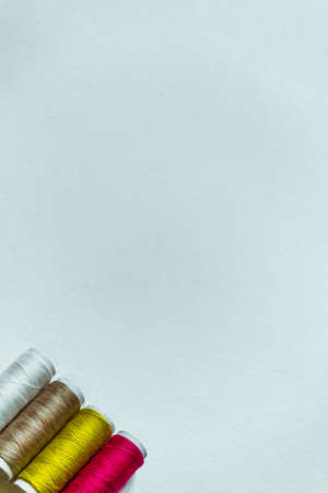Vertical white background with four skeins of thread of different colors.の写真素材