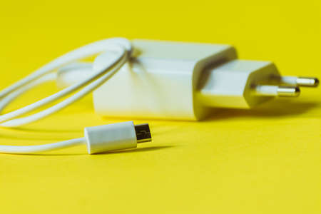 White charger with micro usb on a bright yellow background.の写真素材