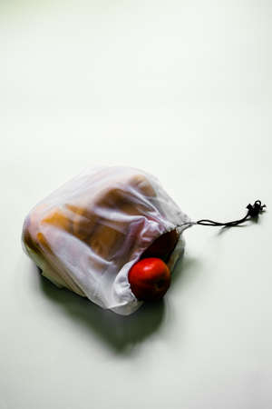 Linen reusable shopping bag for vegetables and fruits on a white background with a place to insert.の写真素材