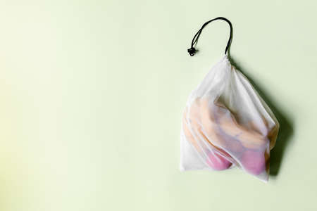 White reusable shopping bag with black rope on a light background with an insert on the left.の写真素材