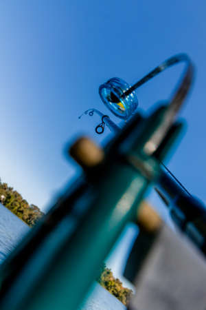 Spinning rod for catching large fish in full length close-up. Fishing and outdoor activities. Fishing in the afternoon on the river. High quality photoの写真素材