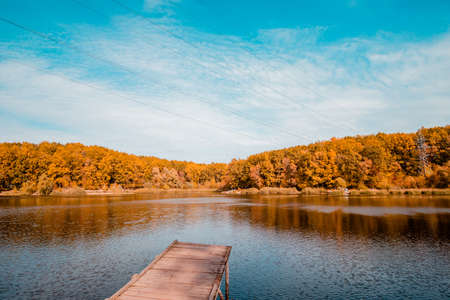 Transparent clear lake with a wooden pier in autumn. Autumn landscape. High quality photoの写真素材