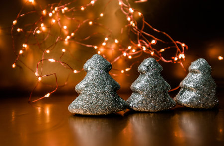Christmas toy shining tree on a gold background with lights. High quality photo