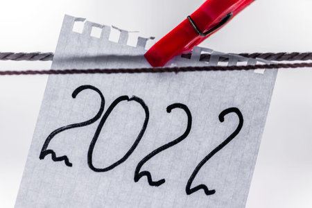 The number 2022 is written in black marker on a scrap of notepad and hangs with a red clothespin....