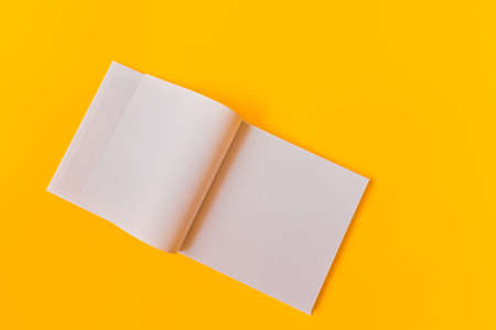 Notebook with white blank pages for notes on a yellow background. High quality photoの写真素材