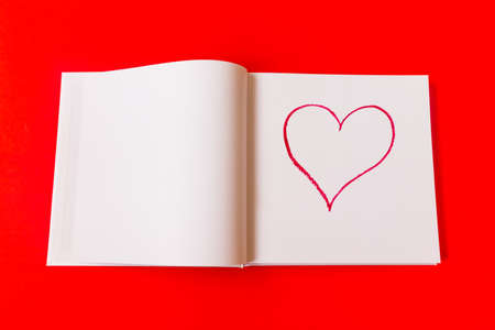 Drawn heart in a notebook on a red background. Happy Valentines Day. High quality photoの写真素材