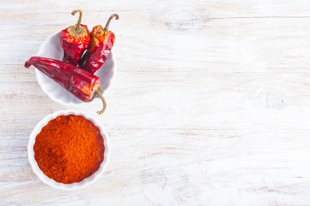 dry chilli pepper on a white wooden tableの写真素材