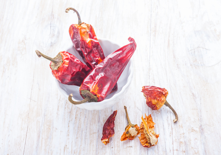 dry chilli pepper on a white wooden tableの写真素材