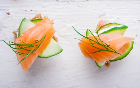 small sandwiches with salmon and cream cheese on a tableの写真素材