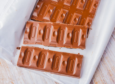 chocolate pieces on white wooden table. studio shotの写真素材