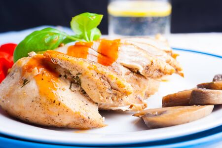 Baked chicken breast sliced on the white plate. studio shotの写真素材