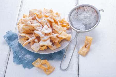 angel wings cakes. faworki on a white wooden table. studio shotの写真素材
