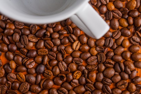 Coffee beans and cup on old wooden table. studio shotの写真素材