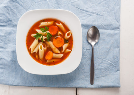 tomato soup with pasta in white plate on table. studio shotの写真素材
