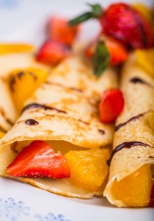 Homemade pancakes with fresh fruit on a white plate. studio shotの写真素材