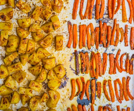 Baked potatoes and carrots on a white plate. studio shotの写真素材