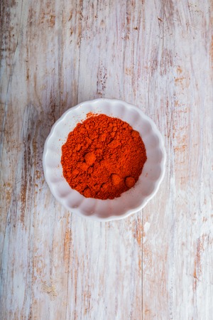 Red pepper in a bowl on wooden table. studio shotの写真素材