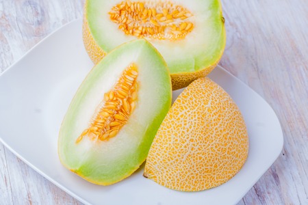 Ripe Galia melon and its slice on plateの写真素材
