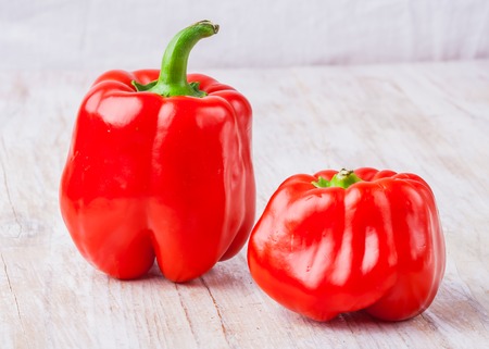 Two red peppers on white wooden tableの写真素材