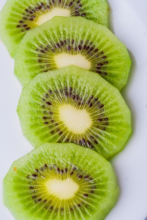 Ripe kiwi fruit on white plate. studio shotの写真素材