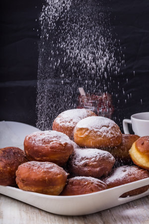 Falling powder sugar on a fresh donutsの写真素材