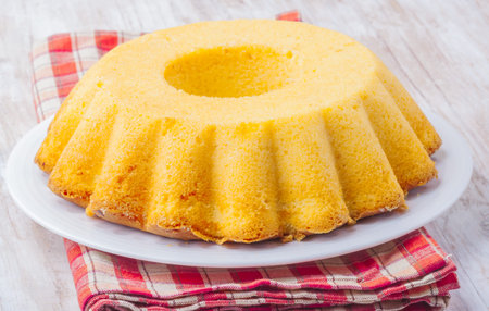 Round-shaped tasty lemon cake on white plate