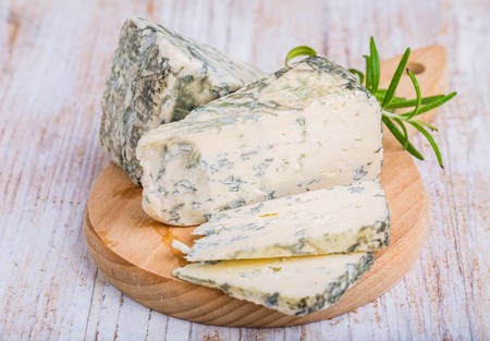 Blue cheese and rosemary on wooden backgroundの写真素材