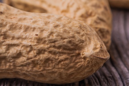Small dry yellow peanuts on wooden table. studio shotの写真素材