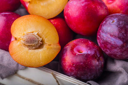 Many ripe plums on old wooden table. studio shotの写真素材