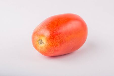 One fresh red tomato isolated on white, studio shotの写真素材