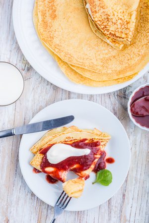 Pancakes with cottage cheese topped with strawberry jam and creamの写真素材