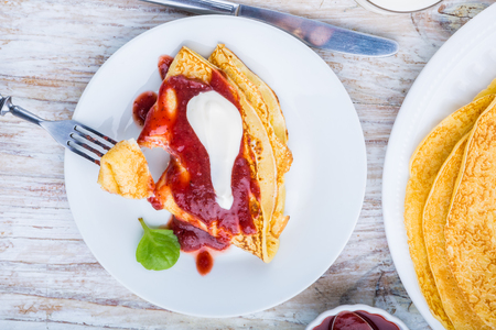 Pancakes with cottage cheese topped with strawberry jam and creamの写真素材