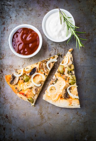 Pieces vegetarian pizza with mushrooms, olives and onions on tableの写真素材