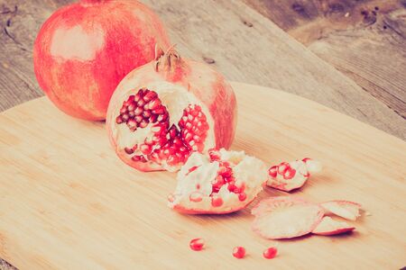 Vintage photo of pomegranates on wooden tableの写真素材