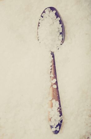 Vintage photo of sea salt grains on a spoonの写真素材
