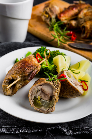 Pork rolls with cucumber and onion on white plateの写真素材
